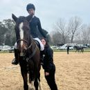 Amazzone in sella a un cavallo nero accanto a un'accompagnatrice