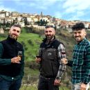 Proprietari Tenuta Trium con calici vino sfondo paese di Notaresco Teramo Abruzzo
