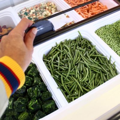 Cliente sceglie verdure surgelate sfuse dal banco freezer
