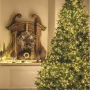 Albero di Natale illuminato accanto a uno specchio classico