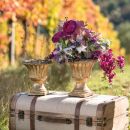 Coppe con fiori viola e rosa appoggiate su un baule vintage