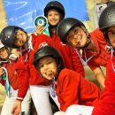 Gruppo di bambini del Team Horse in divisa rossa durante una festa