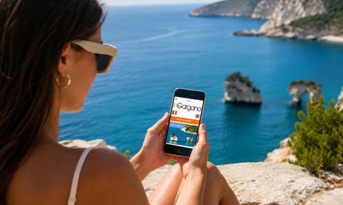 ragazza al mare con smartphone mentre guarda l'App InGargano Portale Turistico Gargano sviluppata da Wainet Web Agency di Teramo