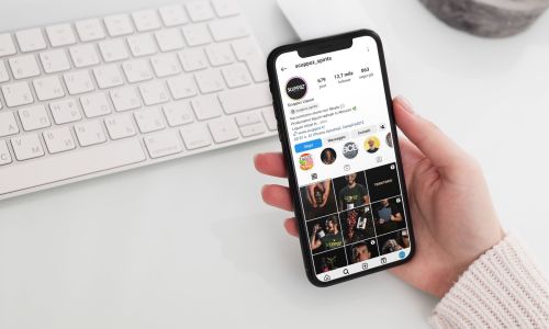 ragazza che guarda la pagina Instagram di Scuppoz liquori a Teramo in Abruzzo dal proprio Iphone sulla scrivania