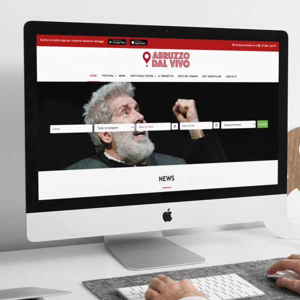 uomo che guarda sull'iMac la home page del sito web di Abruzzo Dal Vivo realizzato da Wainet Web Agency di Teramo