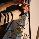 Mano mentre appende palline decorative a un albero in metallo