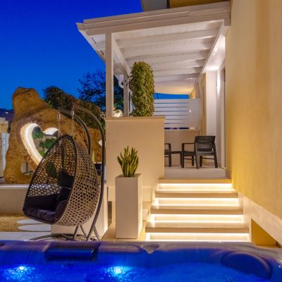 Patio notturno della suite Iris con vasca idromassaggio illuminata e poltrona sospesa