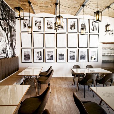 Sala del ristorante Furno arredata con tavoli, sedie e parete fotografica