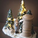 Villaggio natalizio in miniatura con faro e alberi innevati