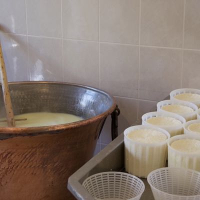 Calderone in rame e stampi durante la lavorazione del formaggio