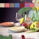 Tavola apparecchiata con palette colori, piatti e frutta