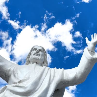 Statua bianca di Cristo fotografata contro il cielo azzurro
