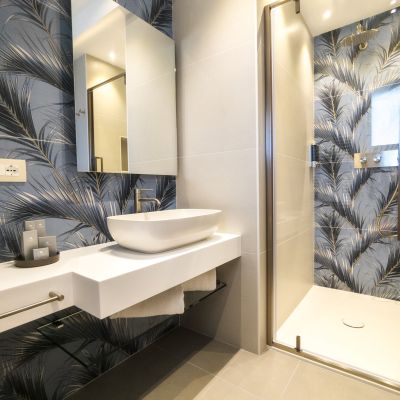 Doppi lavabi e doccia nel bagno con pareti botaniche della suite Iris