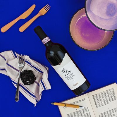 Vino rosso abruzzese con calici e accessori in uno still life su sfondo blu
