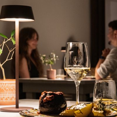 Tavolo con piatto, calice e lampada durante la cena