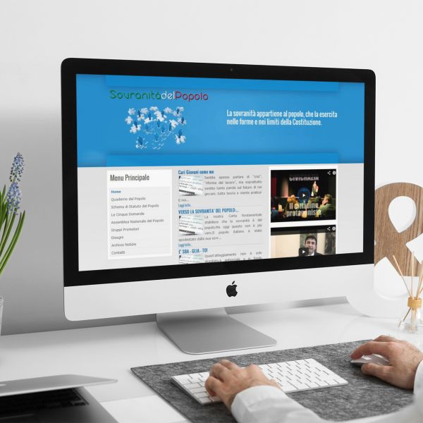 uomo che guarda sull'iMac la home page del sito web della Sovranità Del Popolo creato da Wainet Web Agency a Teramo in Abruzzo