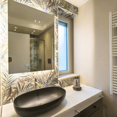 Lavabo scuro e specchio botanico nel bagno della suite Ortensia del Residence Aleden di Vieste