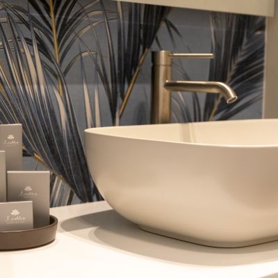 Lavabo bianco e parete botanica nel bagno della suite Iris del Residence Aleden di Vieste