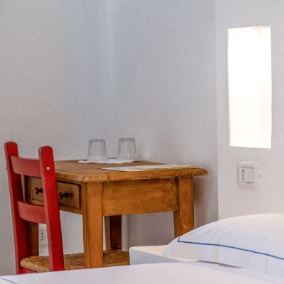 Tavolino in legno e sedie rosse accanto al letto