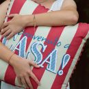 Donna che stringe un cuscino a righe con scritta Travel to Asia