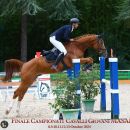 Amazzone nella finale del campionato mentre supera un ostacolo blu