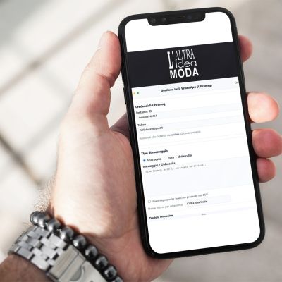 Mano con smartphone che mostra il software WhatsApp Marketing di Altra Idea Moda per gestire campagne promozionali