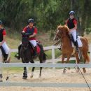 Allievi Team Horse in divisa rossa durante una lezione a cavallo