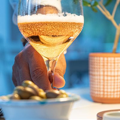 Calice di vino bianco e ciotola di olive sulla tavola