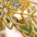 Dettaglio di un ornamento dorato con perle e cristalli