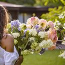 Donna parzialmente nascosta da un grande bouquet di fiori pastello