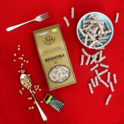 Confezione di minestra di legumi con pasta e ingredienti disposti sul set