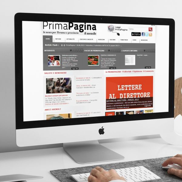 uomo che guarda sull'iMac la home page del sito web di Prima Pagina creato da Wainet Web Agency di Teramo