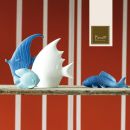 Pesci decorativi in ceramica davanti a una parete a righe rosse