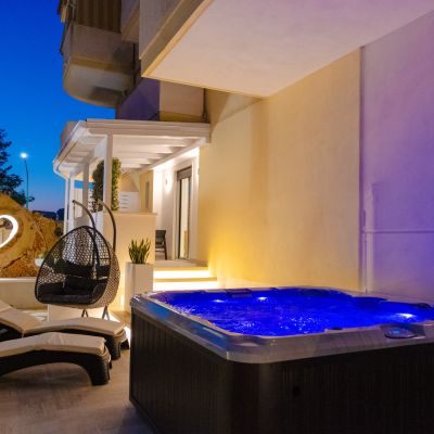 Vasca idromassaggio illuminata di blu nel patio notturno della suite Iris