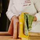 Cuoca mostra le sfoglie gialla, verde e rossa della pasta all'uovo tricolore