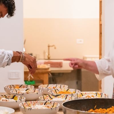 Cuoco mentre serve i piatti preparati per la cena agli ospiti