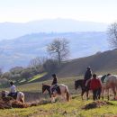 Gruppo Team Horse durante una passeggiata a cavallo con panorama sulle colline