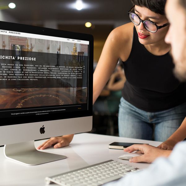 ingegneri che guardano sull'iMac la home page del sito web di Antichità Preziose di Teramo creato dall'agenzia web Wainet di Teramo Abruzzo