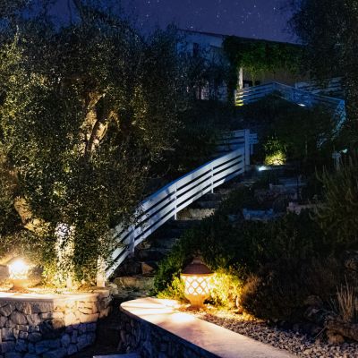 Giardino e vialetto illuminati di notte allo Shanti B&B