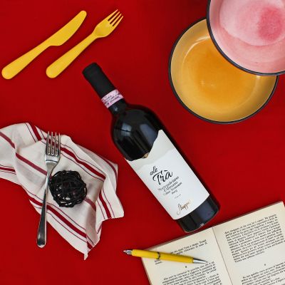 Bottiglia di vino rosso abruzzese su tavola apparecchiata con calici colorati