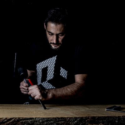 Artigiano Gruppo Rodi mentre lavora una tavola di legno