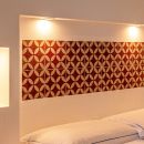 Letto della camera Rossa con testiera decorata e luci laterali