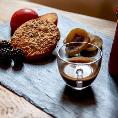 Vassoio in vetro grigio con biscotti, more e bevanda calda