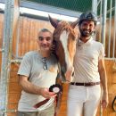 Due uomini sorridono accanto a un cavallo nelle scuderie del Team Horse di Teramo