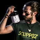 Ragazzo che tiene bottiglia di liquirizia mentre la guarda Scuppoz su Instagram a Teramo in Abruzzo