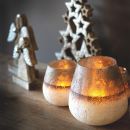 Portacandele dorati con stelle decorative e figure natalizie