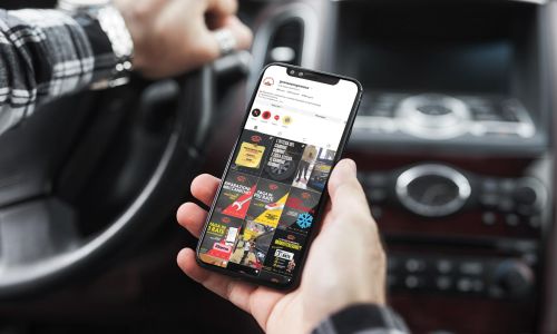 Uomo in auto con iPhone durante la visualizzazione dei contenuti Instagram di Gran Sasso Gomme gestiti da Wainet Web Agency di Teramo