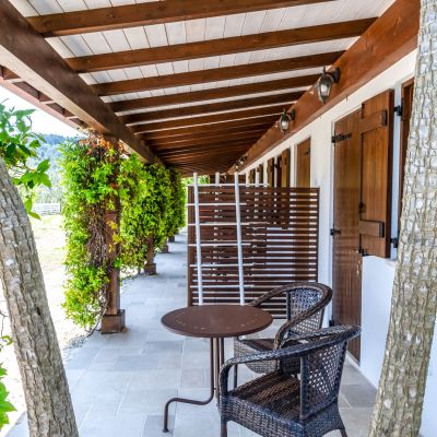 Portico delle camere con tavolino, sedie e vegetazione