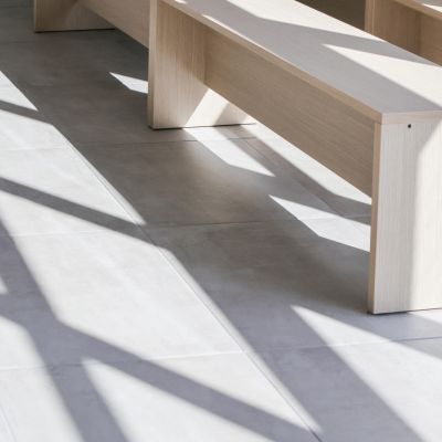Panche in legno illuminate dalla luce naturale nella sala del commiato
