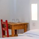 Tavolino in legno e sedie rosse accanto al letto